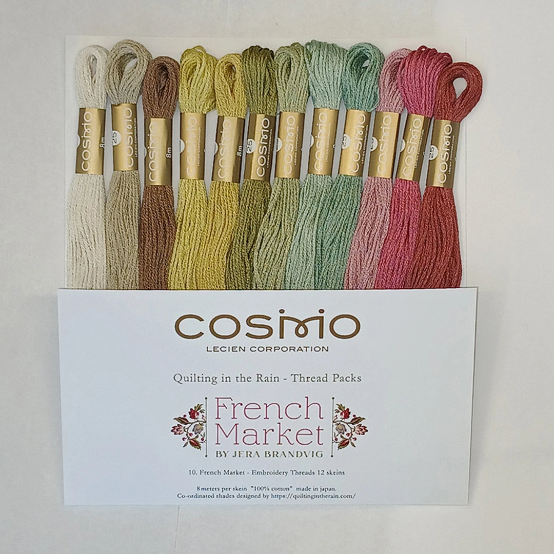 A set of 12 Cosmio embroidery thread packs in French Market colors, arranged vertically behind their white cardboard packaging box on a clean white background.