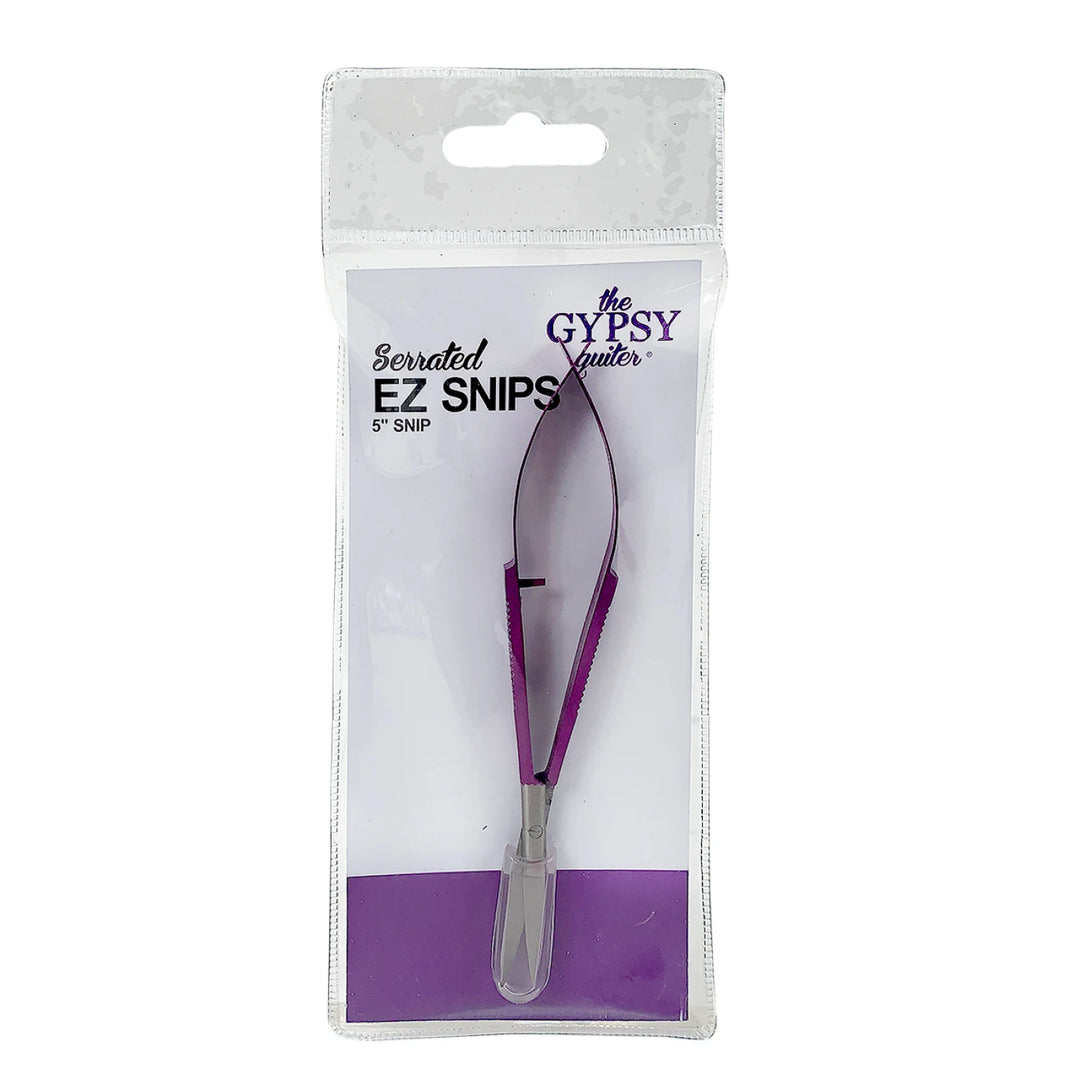 Serrated EZ Snips 5" snap in purple and silver, packaged in a clear plastic sleeve with a white backing card. The packaging features the brand name &